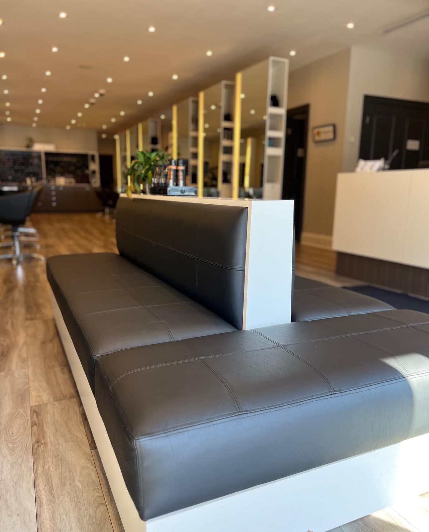 Black upholstered commercial bench seating built for a salon interior